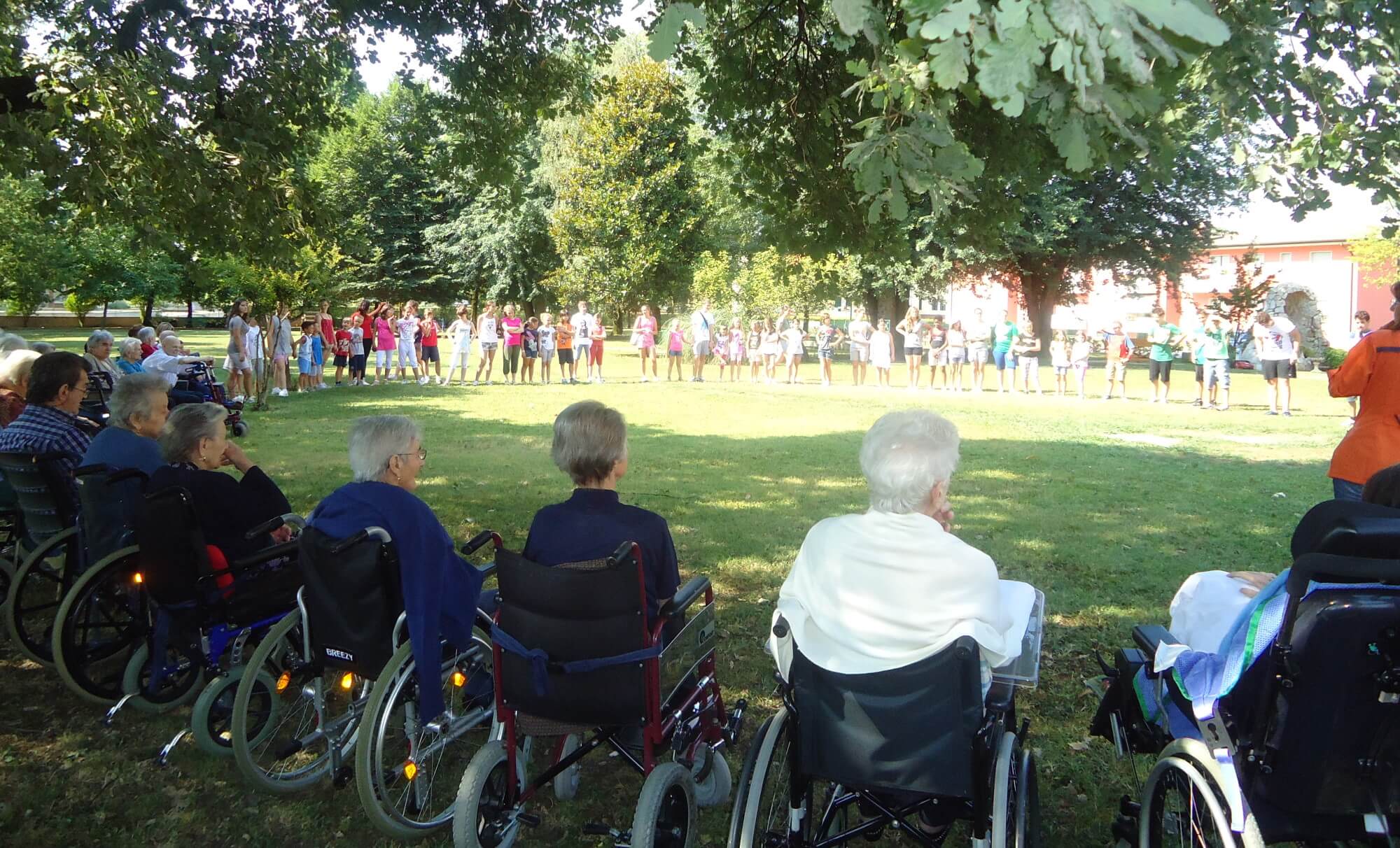 Anziani nel parco in cerchio con studenti