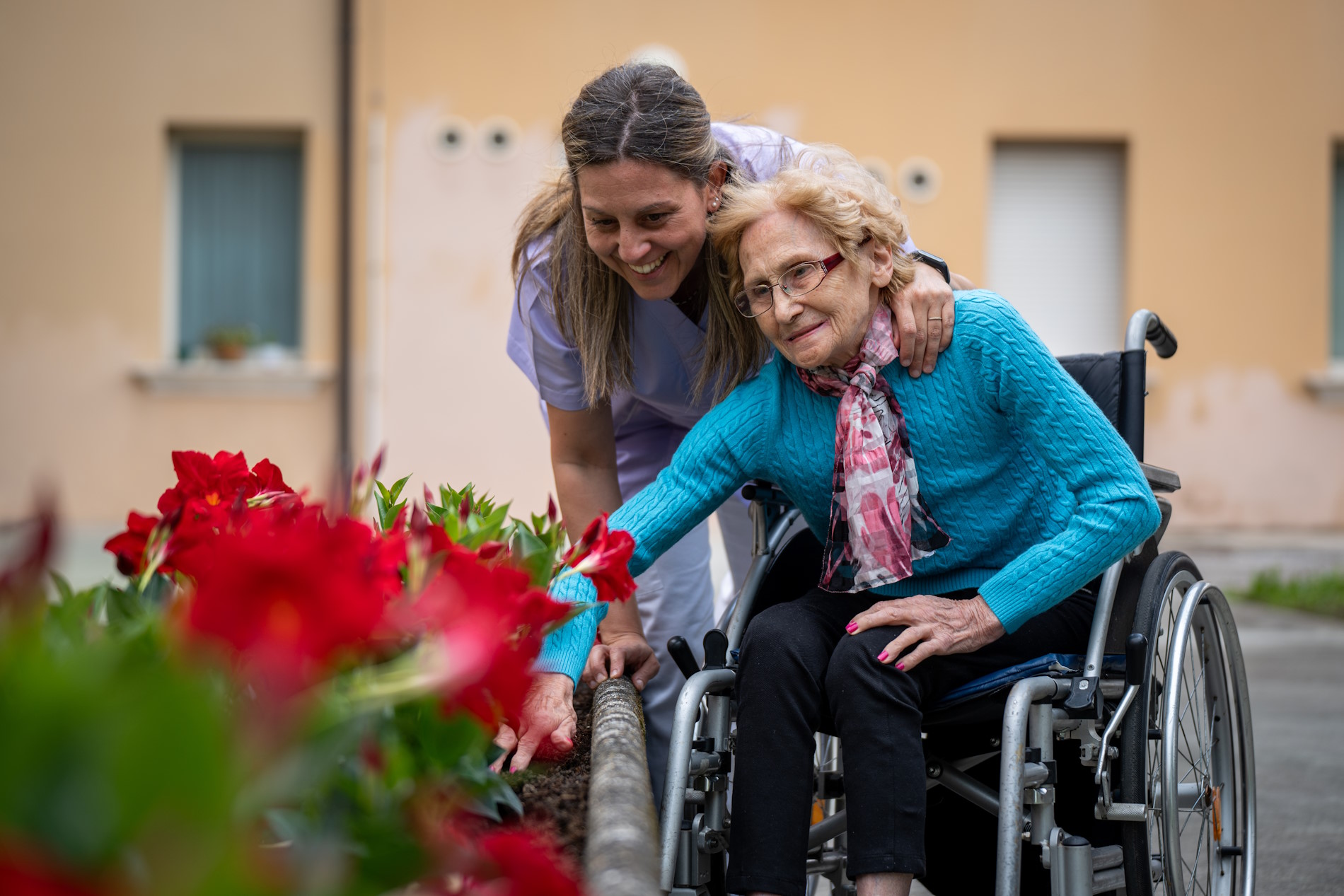 operatrice e anziana con fiori rossi