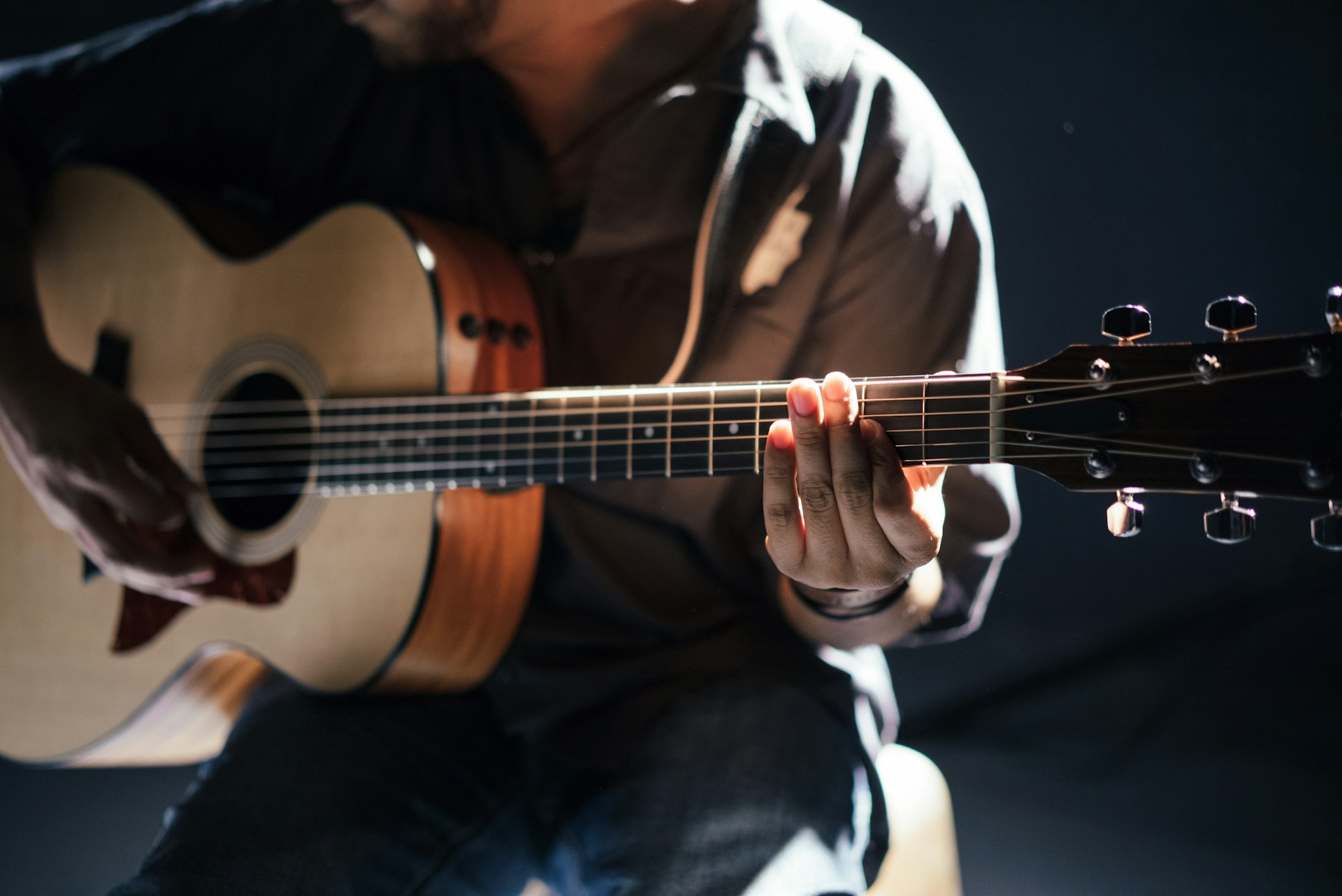 Persona che suona la chitarra acustica